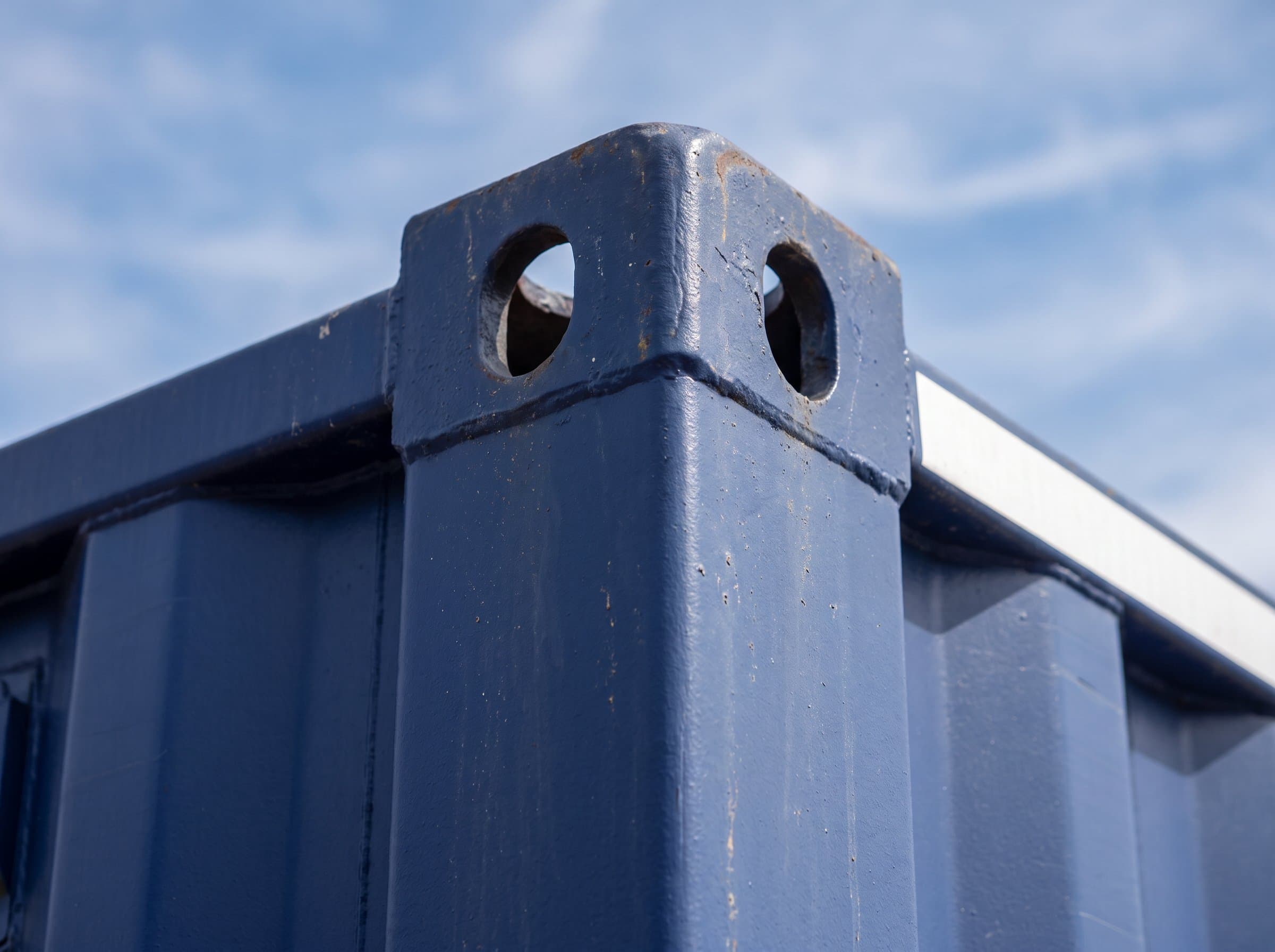 Exterior close-up of ISO corner casting on a factory navy blue 40ft high-cube new one-trip shipping container