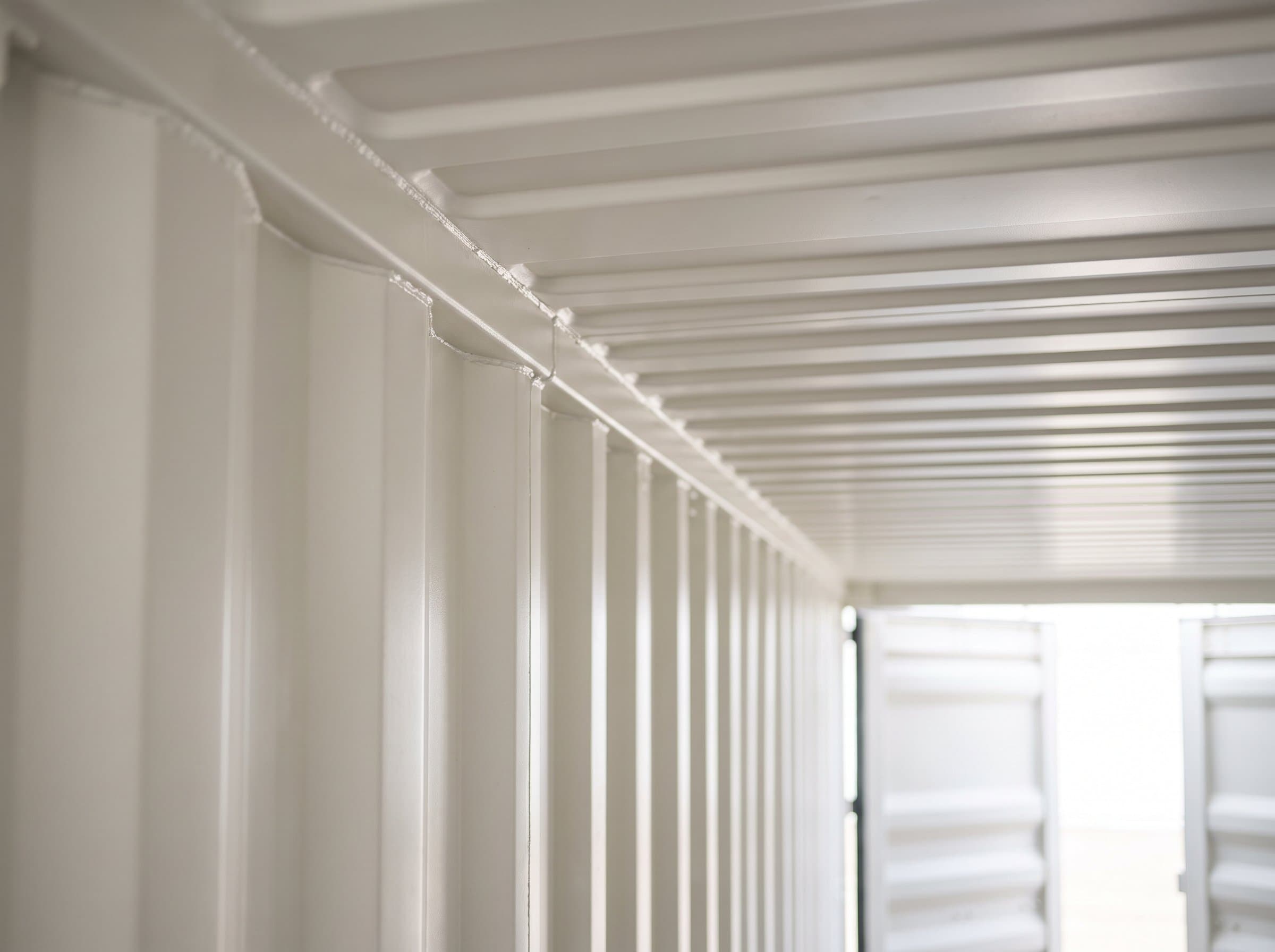 Upper interior corner of a brand-new 40ft high-cube one-trip container showing crisp factory wall-ceiling seam